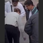 Colaboradores limpian los zapatos del presidente de la SCJN, Hugo Aguilar